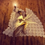 Deborah Goffe in repose on a lacy doily black against a wood floor.